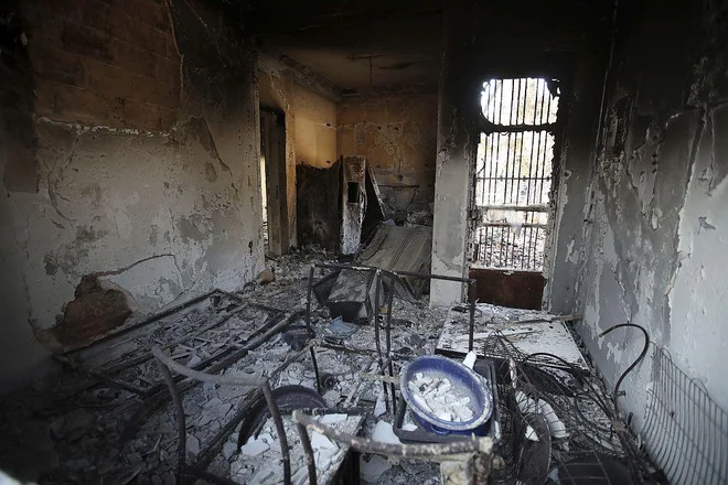 Reševalci v Mati pregledujejo požgane hiše. FOTO: AP