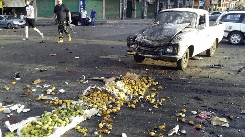 Fotografija: Posledice enega od treh samomorilskih napadov v mestu Sveida na jugozahodu Sirije. FOTO: AP