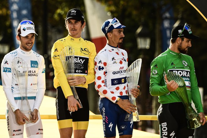 (L-R) France's Pierre-Roger Latour (L) wearing the best young's white jersey, Tour de France winner Great Britain's Geraint Thomas wearing the overall leader's yellow jersey, France's Julian Alaphilippe wearing the best climber's p