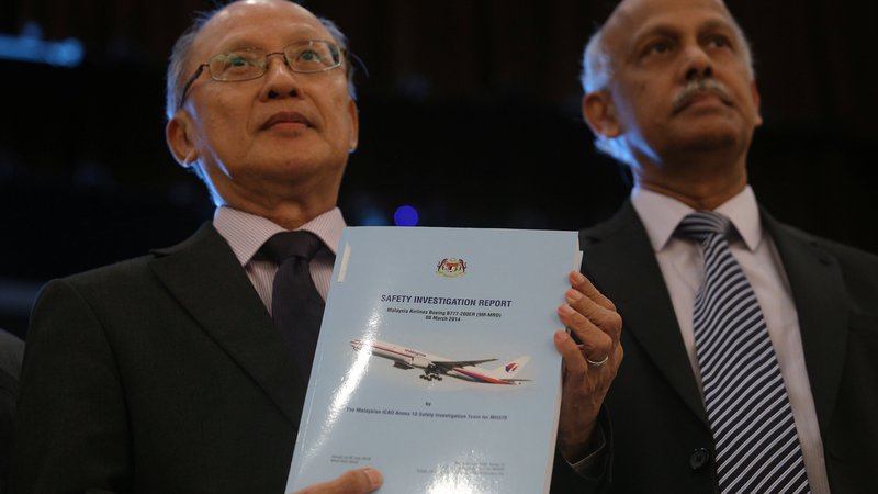 Fotografija: Glavni preiskovalec Kok Soo Chon (desno) v roki drži poročilo o izginulem malezijskem letalu MS370, ki obsega 495 strani. FOTO: Reuters