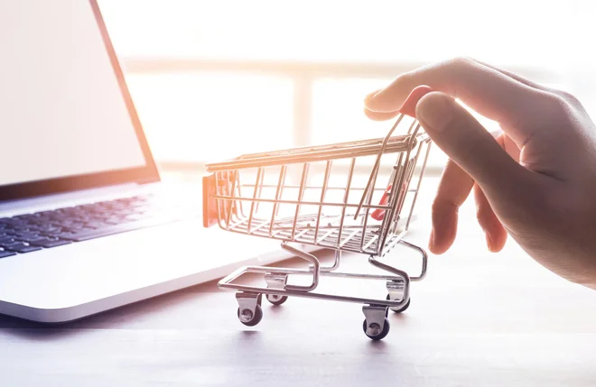 Online shopping concept with woman hand and cart