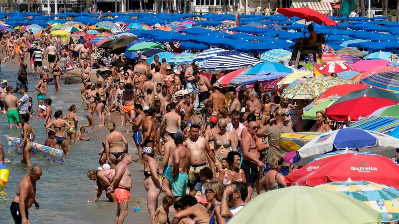 Fotografija: Turisti v Španiji med vročino iščejo ohladitev v morju. FOTO: Reuters