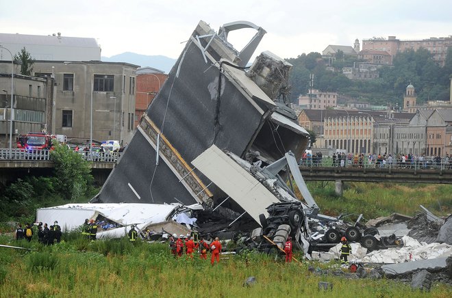 Na severu Italije se je med hudim deževjem porušil avtocestni viadukt. Na avtomobile in stavbe se je podrlo okoli sto metrov konstrukcije mostu Ponte Morandi. FOTO: Reuters