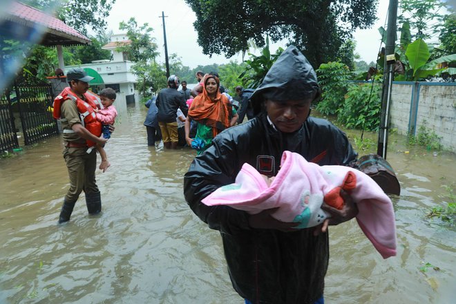 Reševanje ljudi, ki so zaradi poplavnih voda ostali ujeti v stavbah. FOTO: AFP