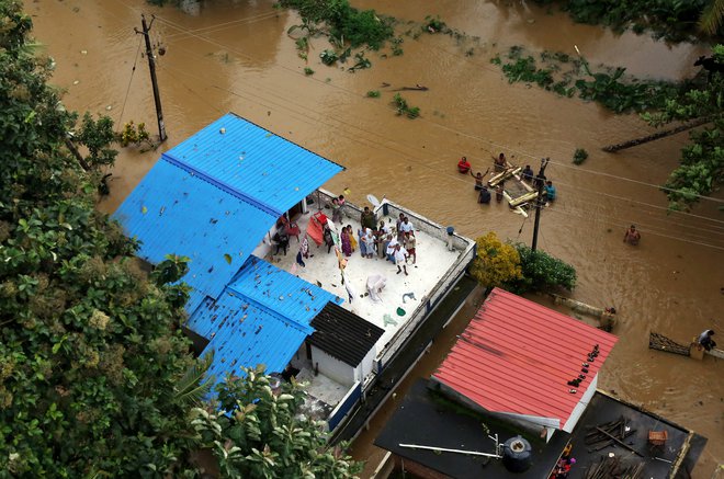 Prebivalci na rešitev čakajo na strehah hiš. FOTO: Reuters