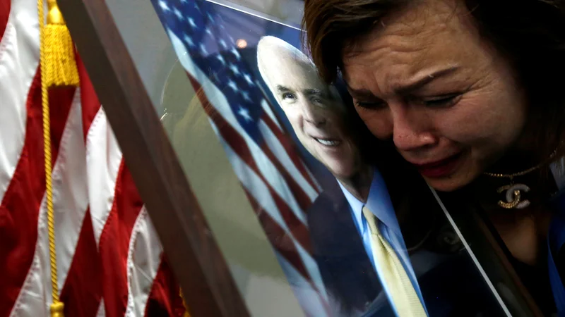 Fotografija: Američanka vietnamskega rodu Mai Tran žaluje za umrlim senatorjem Johnom McCainom na ameriškem veleposlaništvu v Hanoju. FOTO: Reuters