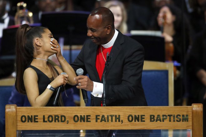 Med svojim govorom na petkovi slovesnosti je pastor 25-letnico držal visoko nad pasom in se ob tem rahlo dotikal njenih prsi. FOTO: Paul Sancya/Ap