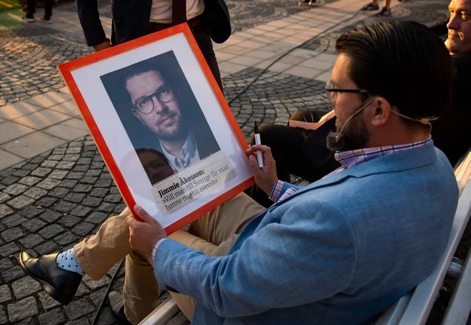 Jimmie Akesson podpisuje svoj portret. FOTO: Jonathan Nackstrand/Afp