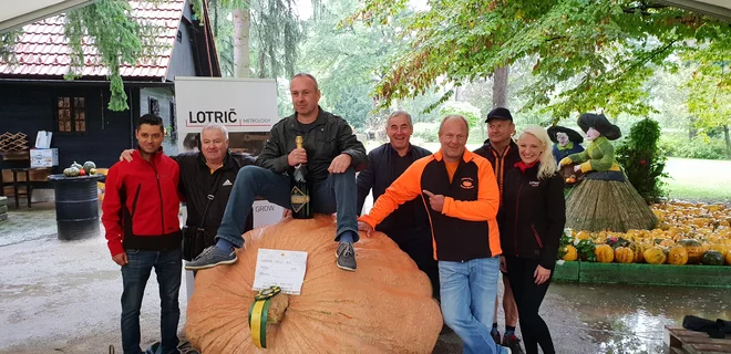 Zmagovalec državnega prvenstva za najtežjo bučo Uroš Fifolt na svoji 607 kg težki buči. FOTO: Mozirski gaj