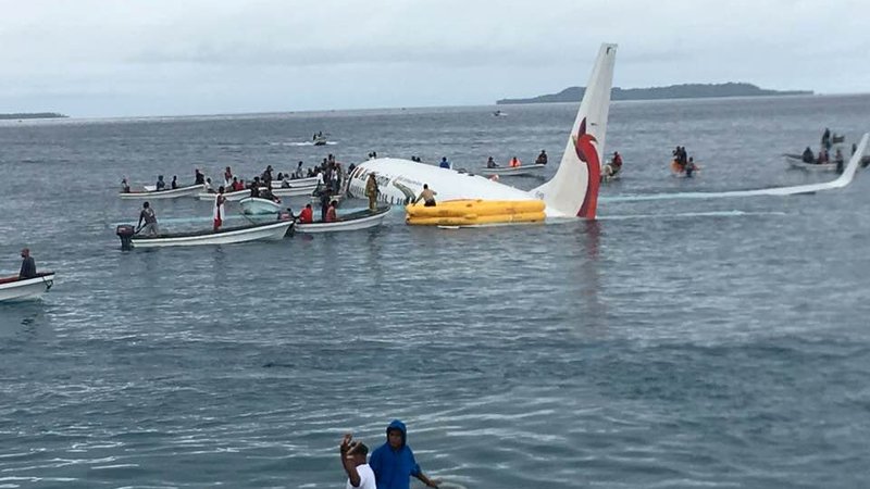 Fotografija: Takole so čolni prispeli do letala, ki je pristalo v vodi ob Mikroneziji. FOTO: James Yaingeluo/Reuters