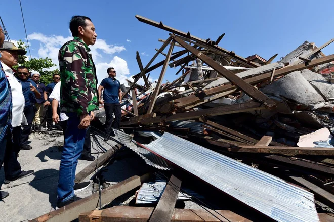 Prostovoljec Thalib Bawano je tiskovni agenciji <em>AFP </em>dejal, da so tri ljudi že rešili iz hotela, ujetih pa ostaja okoli petdeset ljudi. FOTO: Agus Suparto/AP