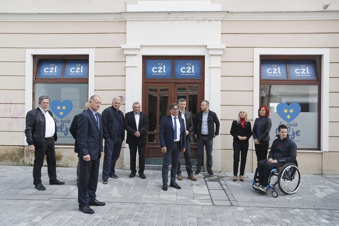 Kandidati Celjske županove liste pred hišo, v kateri so za sto evrov na mesec najeli prostore pred lokalnimi volitvami. FOTO: Leon Vidic/Delo