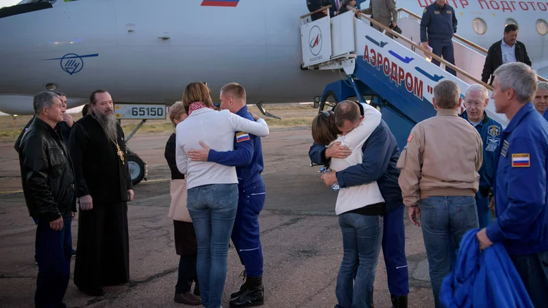 Fotografija: Nasa je objavila fotografijo sreče, ki je preplavila družine astronavta in kozmonavta, ki so si padli v objem na letališču Krajnij. FOTO:NASA/Bill Ingalls/AFP