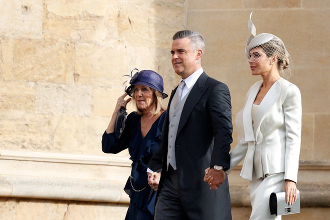 Poleg članov kraljeve družine so bili med povabljenci tudi številni zvezdniki. Na fotografiji sta britanski pevec Robbie Williams in žena, ameriška igralka Ayda Field. FOTO: Adrian Dennis/Reuters