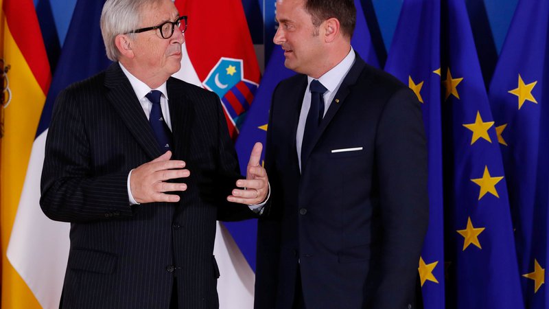 Fotografija: Luksemburški premier Xavier Bettel (desno) v družbi veliko bolj znanega rojaka, predsednika evropske komisije Jean-Clauda Junckerja. FOTO: Reuters