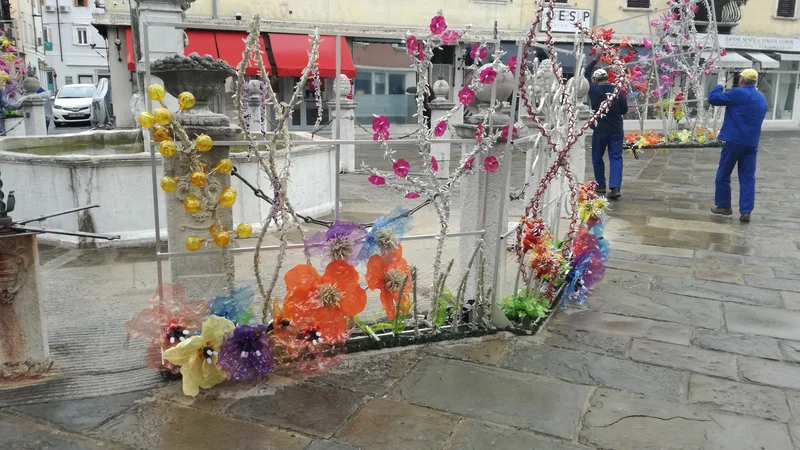 Fotografija: Delavci občinskega komunalnega podjetja Marjetica so le dobro uro pred napovedanim protestom zaradi oskrunjenja Da Pontejevega vodnjaka s kičastim novoletnim okrasjem, s katerim želi župan Popovič v Koper privabiti obiskovalce, dekoracijo odstranili. Foto Martin Nedoh