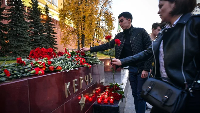 Ljudje na kraju tragičnega dogodka že polagajo sveče in cvetje. FOTO: Alexander Nemenov/Afp