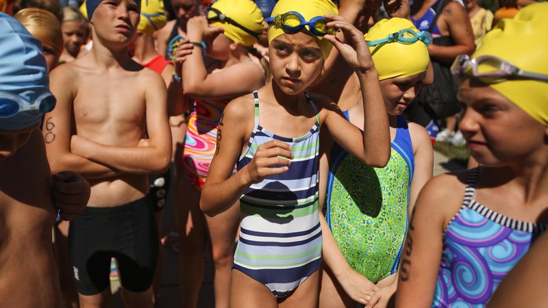 Fotografija: Tirajeh Vossoughi-Horton, 9, puts on her goggles as the racers wait to begin the Kids TRI for Kids Triathlon on Sunday, Aug. 4, 2013, at White River State Park in Indianapolis. Adam Wolffbrandt / The Star