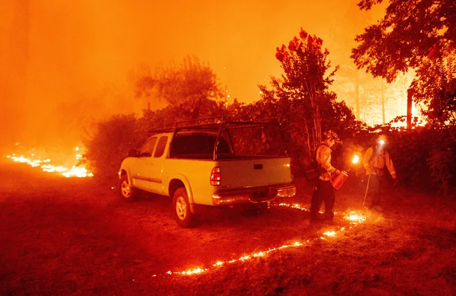 Gasilci poskušajo požar ustaviti s požigom. FOTO: Josh Edelson/AFP