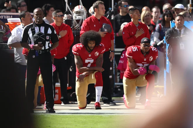 Colin Kaepernick je uvedel klečanje med igranjem himne. FOTO:  Ezra Shaw/AFP