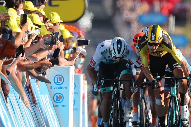 Sporni trenutek, Peter Sagan (levo) se je za las izognil telefonu na palici in se naslonil na Wouta van Aerta. FOTO: Thibault Camus/AFP
