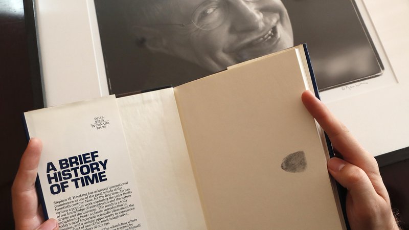 Fotografija: Knjiga Kratka zgodovina časa s prstnim odtisom avtorja Stephena Hawkinga. FOTO: Frank Augstein/AP