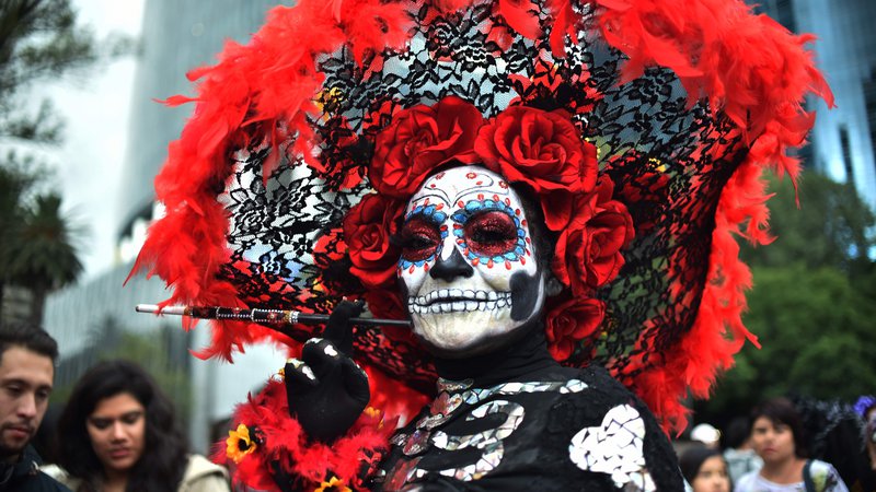 Fotografija: Mehičani preoblečeni kot "Catrina" na paradi "Catrinas" v Mexico Cityju. Mehičani se pripravijo na praznovanje dneva mrtvih. Lik la Catrine je ustvaril karikaturist Jose Guadalupe Posada, znan po svojih risbah tipičnih lokalnih, folklornih prizorov, družbeno-politične kritike in ilustracij okostnjakov ter lobanj, vključno z La Catrino. Foto Rodrigo Arangua Afp