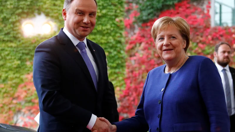 Fotografija: Nemška kanclerka Angela Merkel pozdravlja poljskega predsednika Andrzeja Dudo v Berlinu. Foto: Fabrizio Bensch/Reuters