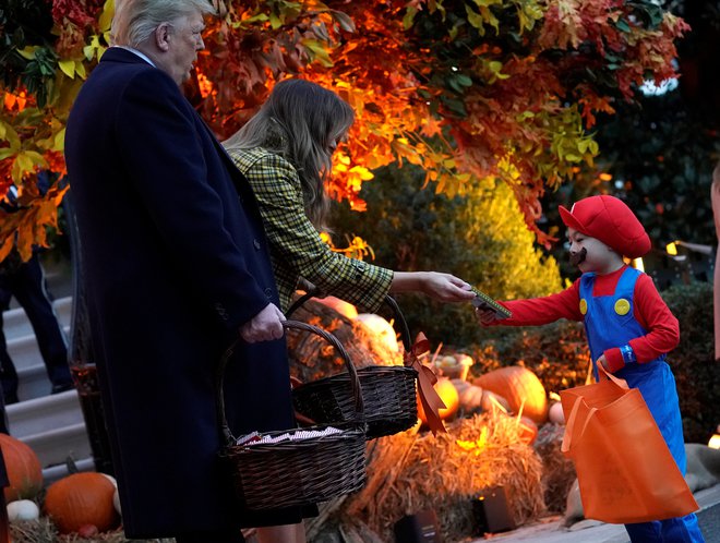 Ameriški predsedniški par je v skladu z običajem noči čarovnic pred Belo hišo otrokom delil sladkarije. Foto Joshua Roberts/Reuters