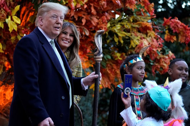 Donald Trump se je med obiskom otrok ob noči čarovnci oprijel faraonske palice deklice, oblečene v egiptovksko vladarko. Foto Joshua Roberts/Reuters