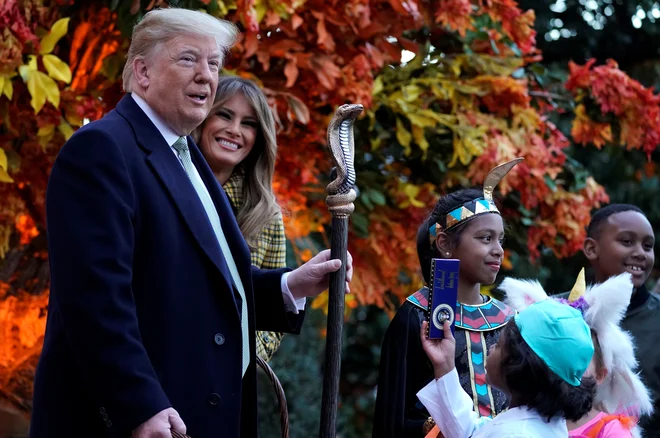 Donald Trump se je med obiskom otrok ob noči čarovnci oprijel faraonske palice deklice, oblečene v egiptovksko vladarko. Foto Joshua Roberts/Reuters