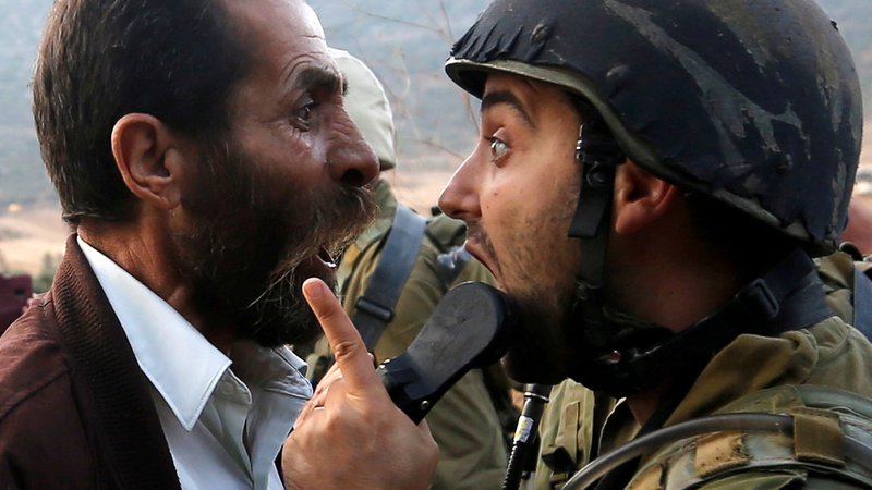 Fotografija: David Grossman je velik zagovornik dialoga miru s Palestinci. Na fotografiji prepir med Palestincem in izraelskim vojakom po nedavnem zaprtju palestinske šole na Zahodnem bregu. FOTO: Reuters