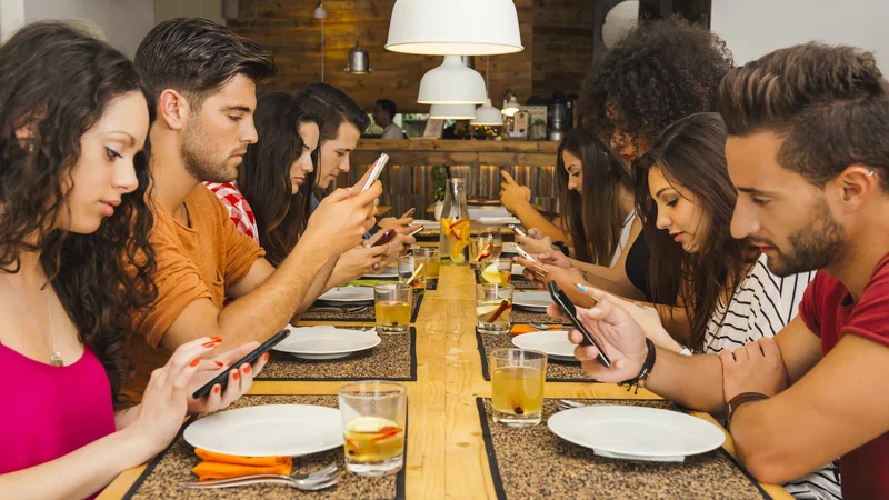 Fotografija: Namesto pogovora strmenje v mobilni telefon? Navada, ki se mnogim zdi že običajna, druge pa jezi.
FOTO Shutterstock