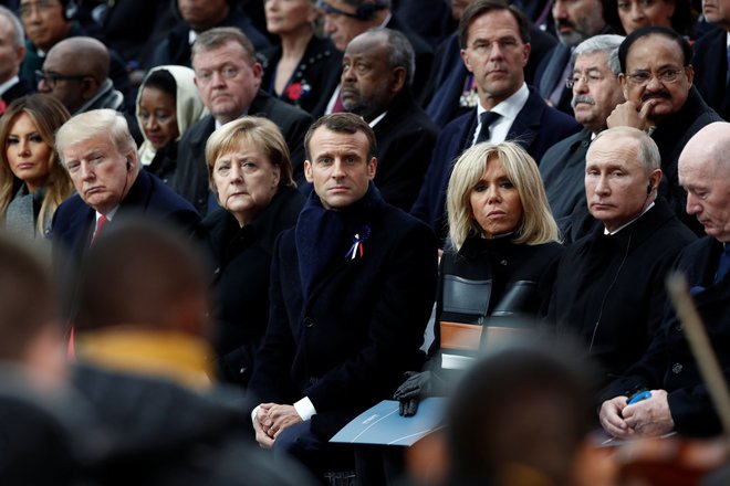 V prvi vrsti so ob Emmanuelu in Brigitte Macron sedeli  Donald Trump v obvezni rdeči kravati, kanclerka Angela Merkel, Vladimir Putin ... FOTO: Reuters