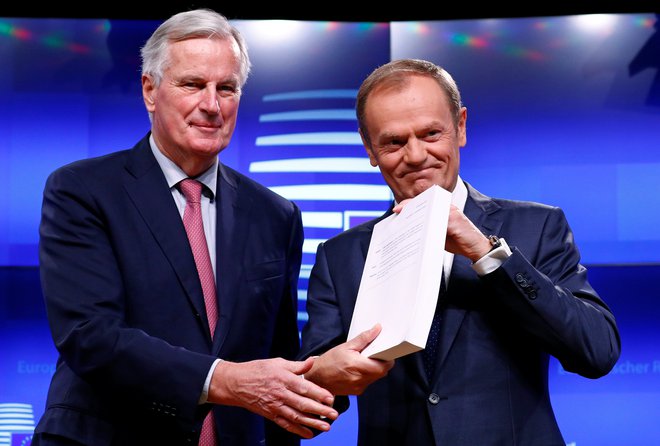 Glavni pogajalec evropske komisije za brexit Michel Barnier skupaj s predsednikov evropskega sveta Donaldom Tuskom, ki v rokah drži 585 strani dolg ločitveni dogovor z Združenim kraljestvom. FOTO: REUTERS/Francois Lenoir