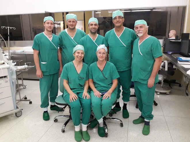 Sodelujoči kirurgi po operaciji: (z desne) dr. Roman Bošnjak, Ljubljana; dr. Levent Sennaroğlu, Ankara; Enrico Muzzi, Trst; dr. Burcak Bilginer, Ankara; Nejc Steiner, Ljubljana; (sedita) dr. Saba Battelino, Ljubljana; dr. Eva Orzan, Trst. FOTO: Arhiv UKC 