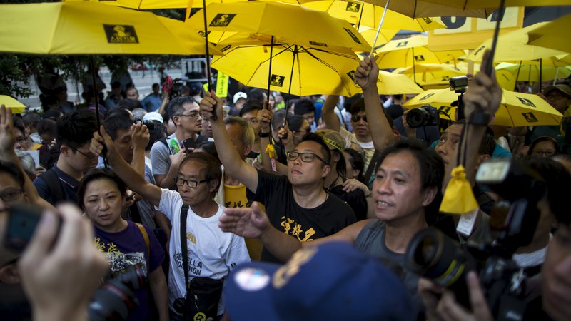Fotografija: Na tisoče ljudi, zlasti študentov, se je leta 2014 udeležilo protestov v središču Hongkonga. Ker so jih oblasti hotele razgnati s solzivcem, so se zaščitili z dežniki, po katerih je gibanje dobilo ime. FOTO: Reuters