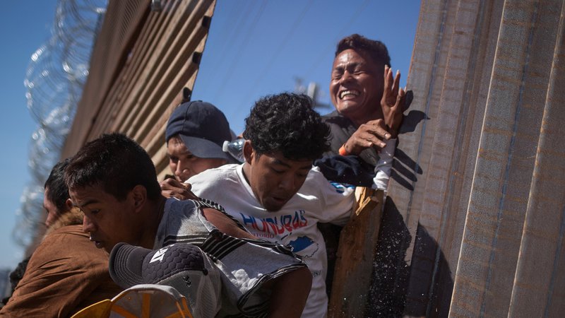 Fotografija: Več sto ljudi je poskusilo prek ograje vdreti na ameriško ozemlje, obmejna policija jih je odgnala s solzivcem. Foto Reuters