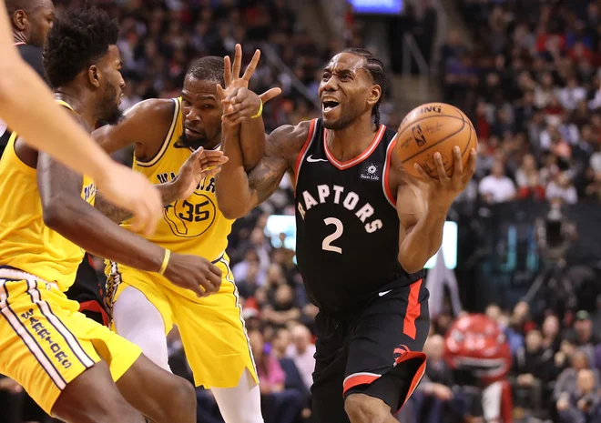 Kawhi Leonard (z žogo) je bil med najzaslužnejšimi za zmago moštva Toronto Raptors nad Golden State Warriors. FOTO: Reuters