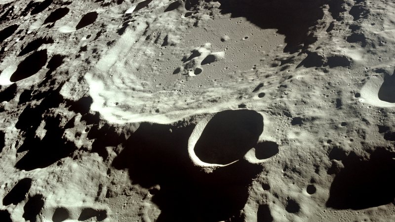 Fotografija: Temna stran meseca oziroma plat Lune, ki je ves čas obrnjena proč od Zemlje, je veliko bolj razgibana in posuta s kraterji. Foto Nasa, Apollo 11