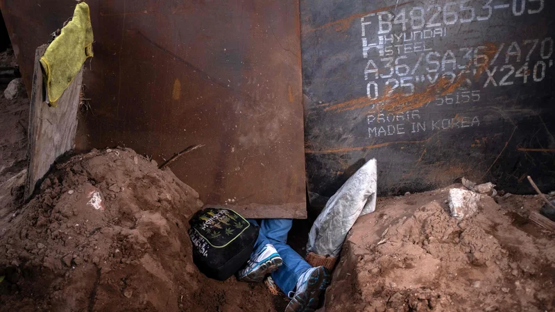 Fotografija: Migrant, ki je v želji po boljšem življenju več kot mesec dni potoval iz Centralne Amerike do ZDA, se plazi skozi luknjo v tleh pod kovinskim zidom na meji, ki ločuje Mehiko in ZDA. Novi mehiški zunanji minister Marcelo Ebrard se je z ameriškim državnim sekretarjem Mikeom Pompeom srečal na "prijateljskem" srečanju ob napetosti zaradi migrantske krize na meji. Foto Guillermo Arias Afp