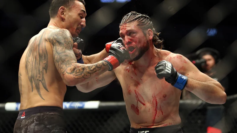 Fotografija: V Torontu sta se na osrednjem dogodku težko pričakovanega spektakla UFC 231 v oktagonu pomerila neporaženi izzivalec Brian Ortega in branilec naslova v peresno lahki kategoriji Max Holloway. Zmage se je s tehničnim nokavtom v četrti rundi veselil Holloway, potem ko je zdravnik presodil, da okrvavljeni in vidno poškodovani Ortega dvoboja ne more nadaljevati. Foto Vaughn Ridley Afp