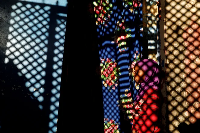 Deklica stoji pred njenim enosobnim bivališčem v Dakarju. Foto Zohra Bensemra Reuters