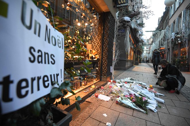 Sveče in rože na kraju napada. FOTO: Patrick Hertzog/AFP