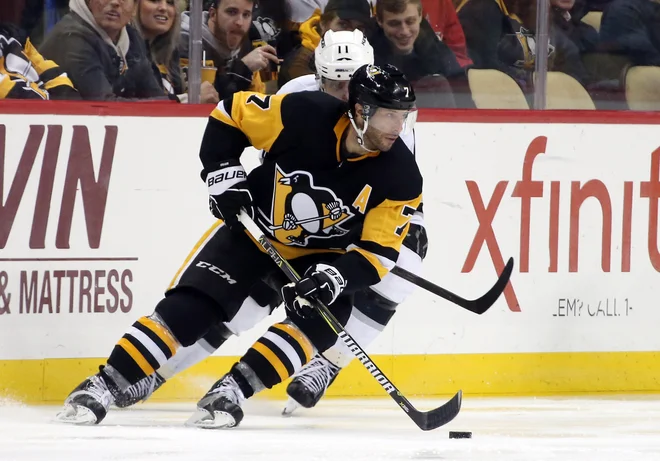 Pittsburghov hokejist Matt Cullen vodi plošček pred Anžetom Kopitarjem (v ozadju). FOTO: Usa Today Sports
