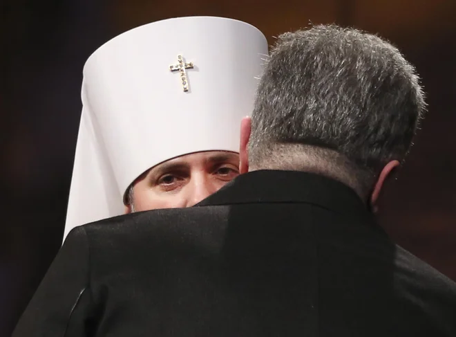 Ukrajinski predsednik Petro Porošenko v objemu z vodjo novoustanovljene ukrajinske cerkve, 39-letnim Epifanijem. Foto: AP