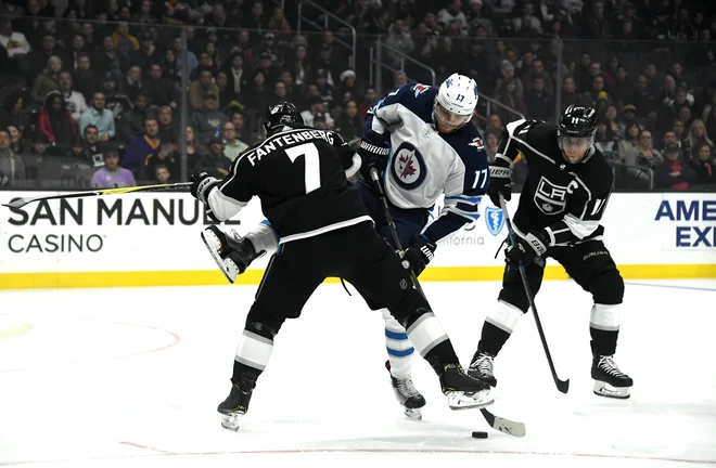 Anže Kopitar v boju z Adamom Lowryjem. FOTO: Reuters