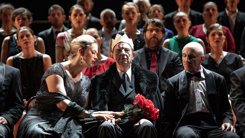 Fotografija: Ko Macbeth drži sabljo, med sedečo odrsko »publiko« stoji tudi Banquo, ki ponavlja isto kretnjo – roko drži v zraku v isti smeri, vendar ta še nima moči, saj je brez nabodala.­ Foto Darja Štravs Tisu