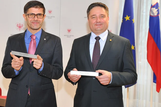 Matjaž Rakovec, novi župan Kranja, je s predhodnikom, Boštjanom Trilarjem, izmenjal tablico z imenom za vrata županova pisarne. Foto Gregor Eržen/mo Kranj