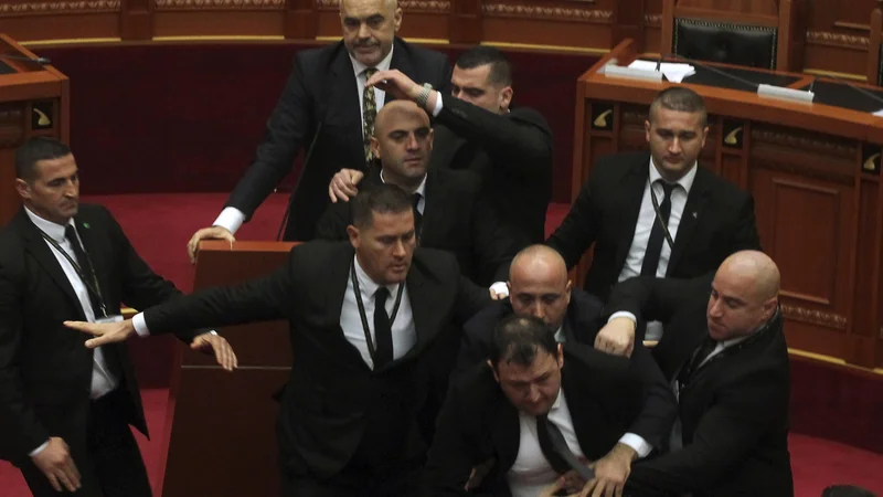 Fotografija: Varnostniki so odstranili iz parlamenta opozicijskega poslanca Endrija Hasa, ki je skušal premierja Edija Ramo obmetavati z jajci. FOTO: AP
